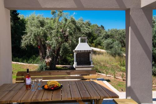 a table with a bowl of fruit and a bottle of wine at ANATOLI VILLAS in Nikiana