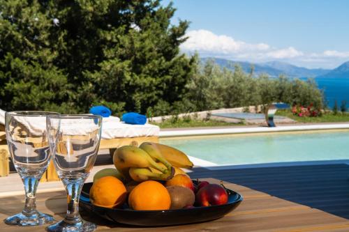 a bowl of fruit on a table next to a pool at ANATOLI VILLAS in Nikiana