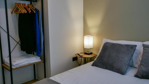 ein Schlafzimmer mit einem Bett und einer Lampe auf einem Tisch in der Unterkunft Flat 3 Castle Street Serviced Apartments in Telford