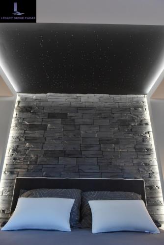 a bedroom with a brick wall and a bed with two pillows at Legacy Marine2 - Zadar, Luxury Suites in Zadar