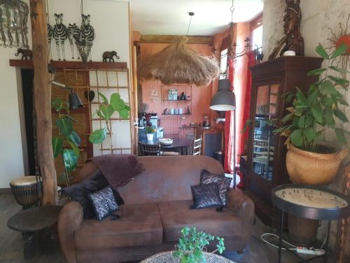 a living room with a brown couch in a room at En pleine nature in Bonneuil-en-Valois