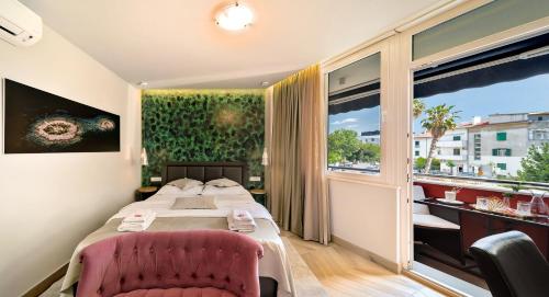 a hotel room with a bed and a large window at Il Giardino Luxury Rooms & Suites in Split