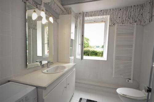 baño con lavabo y aseo y ventana en Le Gîte De L'Ouche Charlot, en Maux