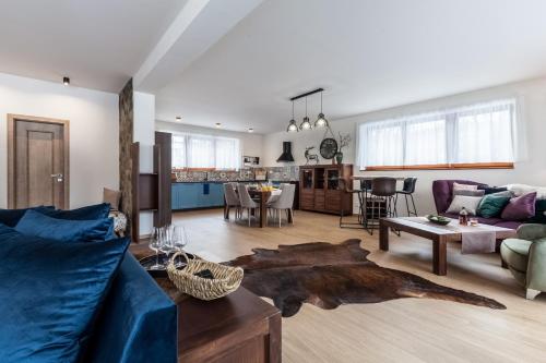 a living room with a blue couch and a table at Chalets Royal, Tatranská Lomnica in Tatranská Lomnica