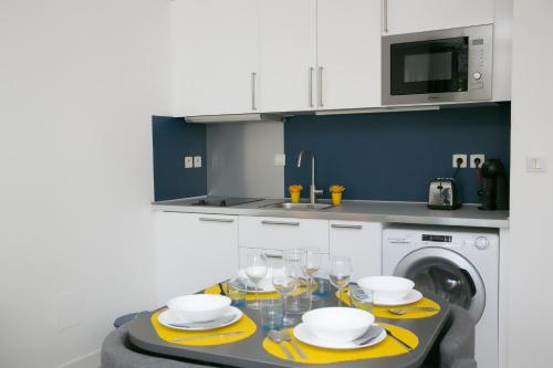 une cuisine avec une table et une machine à laver dans l'établissement T2 proche Centre historique Gare St-Roch avec Parking, à Montpellier
