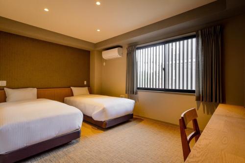 Postel nebo postele na pokoji v ubytování ikoi HOTEL