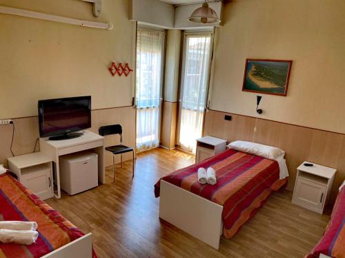 ein Hotelzimmer mit 2 Betten und einem TV in der Unterkunft Affittacamere Metro Fiera in Pero