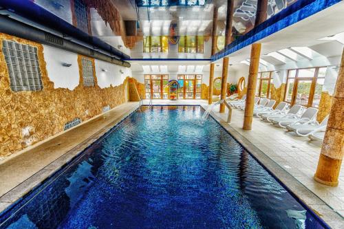 a swimming pool with chairs in a building at Panorama_SPA in Trzęsacz