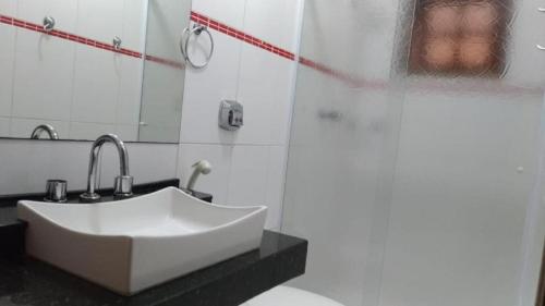 a bathroom with a white sink and a shower at Hotel Reimann in Indaiatuba