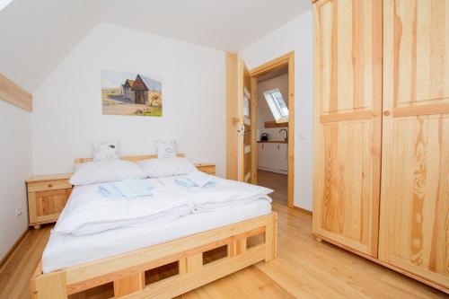 a bedroom with a large bed with white sheets at Apartamenty Toporowe Domki in Witów