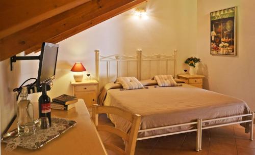 a bedroom with a bed and a table with a bottle of wine at Pessighette Dimora Di Campagna in Bosa