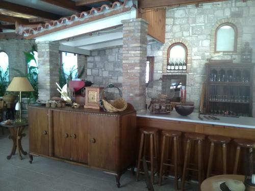 a bar with a counter and stools in a room at Nicolas Village Club in Néos Erineós