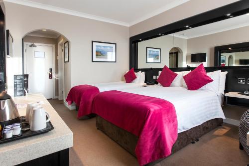 a large hotel room with two beds with red blankets at Ashling Hotel Dublin in Dublin
