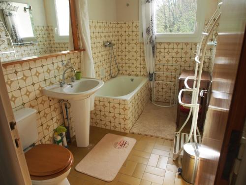 a bathroom with a tub and a sink and a toilet at Escale en Revermont in Saint-Lothain