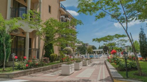 a sidewalk in front of a building with flowers and plants at Bendita Mare Aparthotel in Golden Sands
