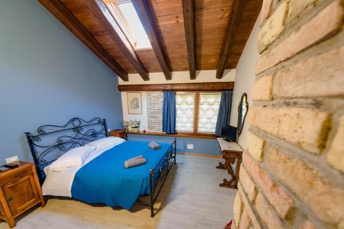 a bedroom with a blue bed and a brick wall at Isola Di Wight in San Michele al Tagliamento