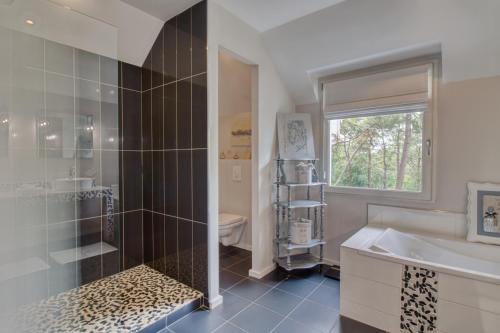 ル・テュケ・パリ・プラージュにあるVilla Vent-Couvertのバスルーム(シャワー、シンク、バスタブ付)