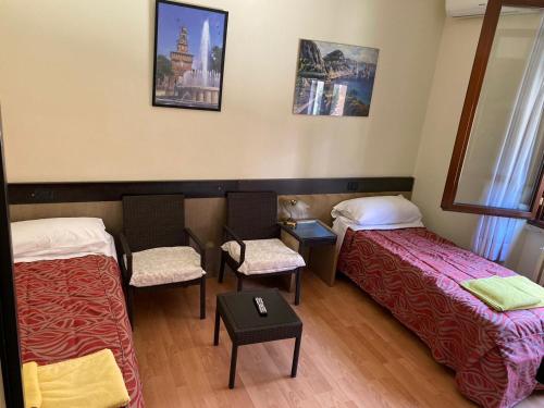a room with two beds and a table and chairs at B&B Santa Monica in Pero