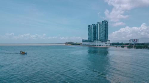 a boat in the water in front of a building at Swiss-Belhotel Kuantan in Kuantan