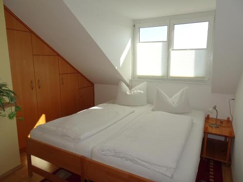 uma cama branca num quarto com uma janela em Haus Holzheimer em Bad Kissingen