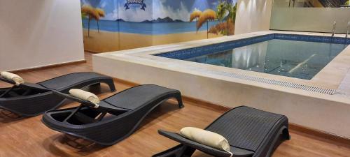 a swimming pool with chairs in front of a swimming pool at Hayat Al Riyadh Hotel in Riyadh