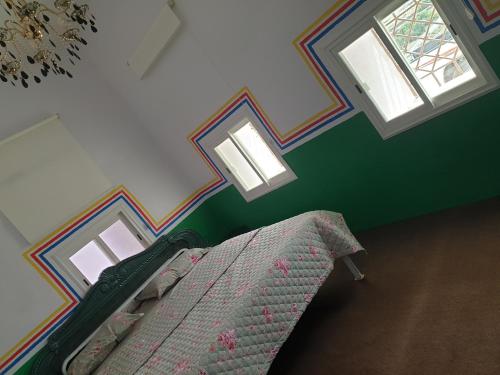 a bedroom with a bed and two windows at منزل ريفي بناء حجري in Al Assan