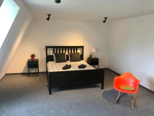 ein Schlafzimmer mit einem Bett und einem roten Stuhl in der Unterkunft Ramer Tower apartment in Old Town in Riga