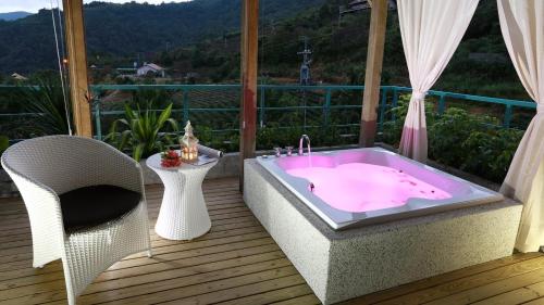 a hot tub on a deck with a chair at Ying Yue Villa in Datong