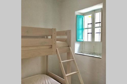 a bunk bed in a room with a window at Casa ALBAYZÍN in Salobreña