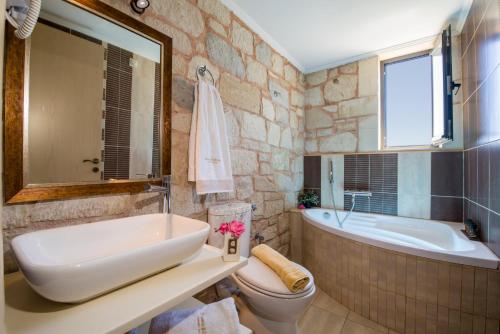 a bathroom with a tub and a toilet and a sink at Villa Christy in Stalos