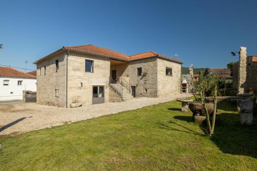 a large stone building with a grass yard at Casa da Veiga in Monção
