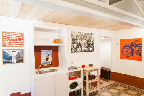 Cette chambre est dotée d'un mur blanc avec des affiches. dans l'établissement Loft viaveneto, à Volterra