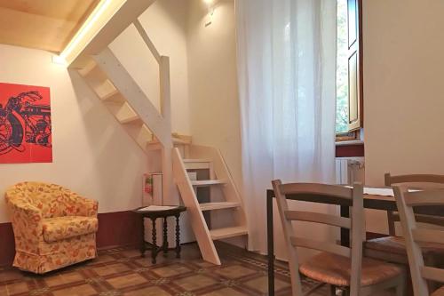 - un salon avec un escalier, une table et une chaise dans l'établissement Loft viaveneto, à Volterra