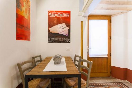 - une salle à manger avec une table et des chaises en bois dans l'établissement Loft viaveneto, à Volterra