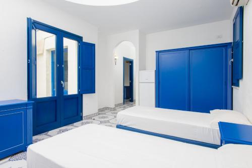 two beds in a room with blue doors at Araba Fenice Village in Torre dell'Orso