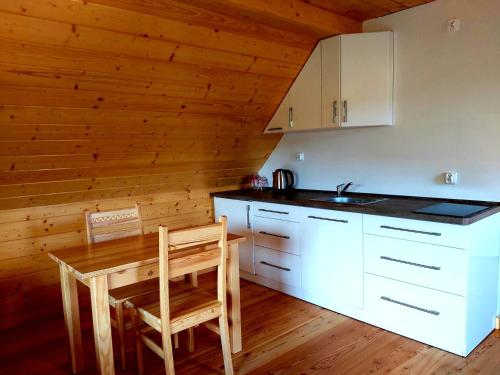 a kitchen with a table and a wooden ceiling at Domki góralskie na Podhalu Zakopane in Tokarnia