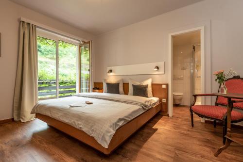 a bedroom with a bed and a large window at Hotel Heintz in Vianden