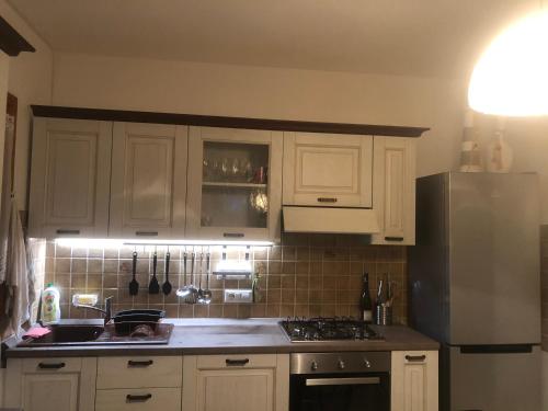 cocina con armarios blancos y nevera de acero inoxidable en Sardegna-Ferienwohnung mit emotionale Meeres Blick, en Torre dei Corsari