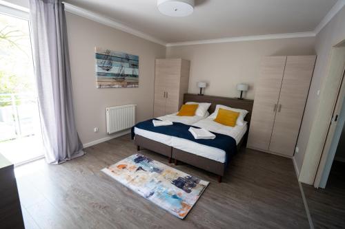 um quarto com uma cama e uma grande janela em Apartament Feniks 12 - 63 m2 em Świnoujście