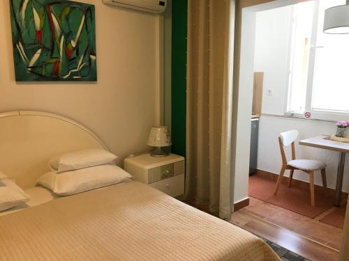 een slaapkamer met een bed, een tafel en een raam bij Apartments - Rooms VESNA in Primošten