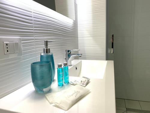 ein Badezimmer mit einem Waschbecken mit zwei blauen Gläsern darauf in der Unterkunft Casa Vacanze Dei Bacini in Porto Cesareo