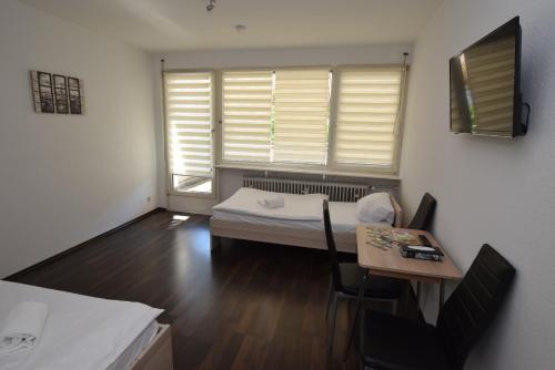 Habitación con cama, mesa y ventana en Apartment Wangen, en Stuttgart