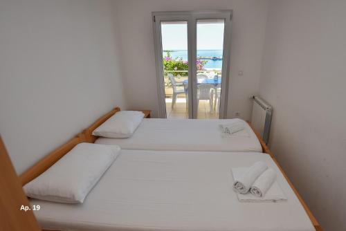 Dos camas en una habitación con vista al mar. en Apartments Bella Sky, en Novalja