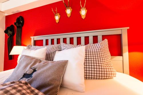 Schlafzimmer mit roten Wänden und einem Bett mit Kissen in der Unterkunft Ferienwohnung Hedwig in Breitnau