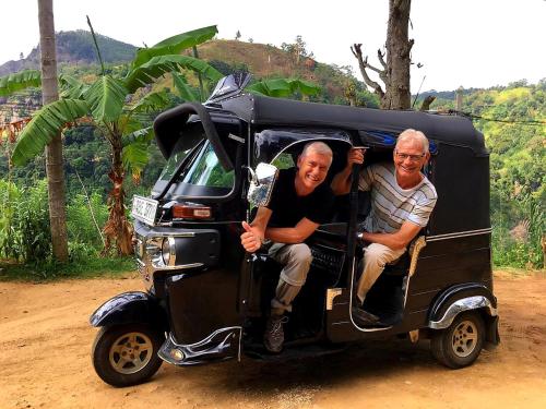 two men sitting in the back of a small vehicle at Leisure Dream Inn in Ella