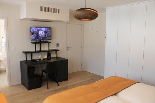 um quarto com uma cama, uma secretária e uma televisão em B&B Atuatuca em Tongeren