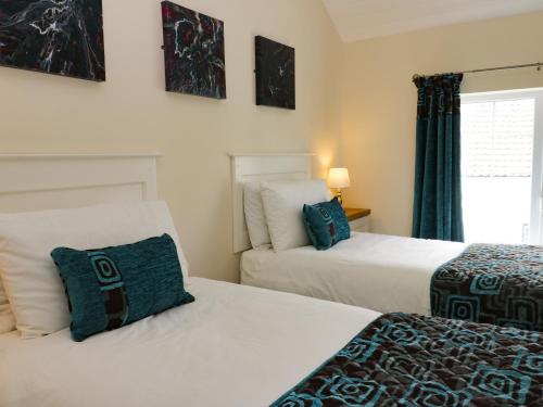una camera da letto con due letti e una finestra di Beech Cottage a Filey