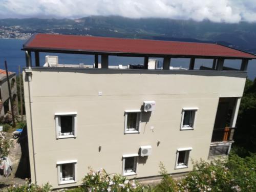 a white building with a red roof at Casa de Laza Apartments in Herceg-Novi