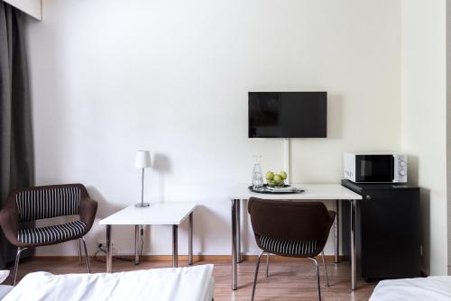 a room with two chairs and a table and a microwave at Hotel Hermica in Tampere