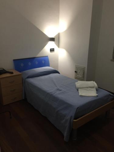 Un dormitorio con una cama azul con luz. en Asselta Hotel, en Cerignola